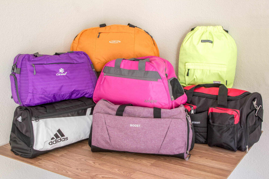 Seven gym bags on a shelf